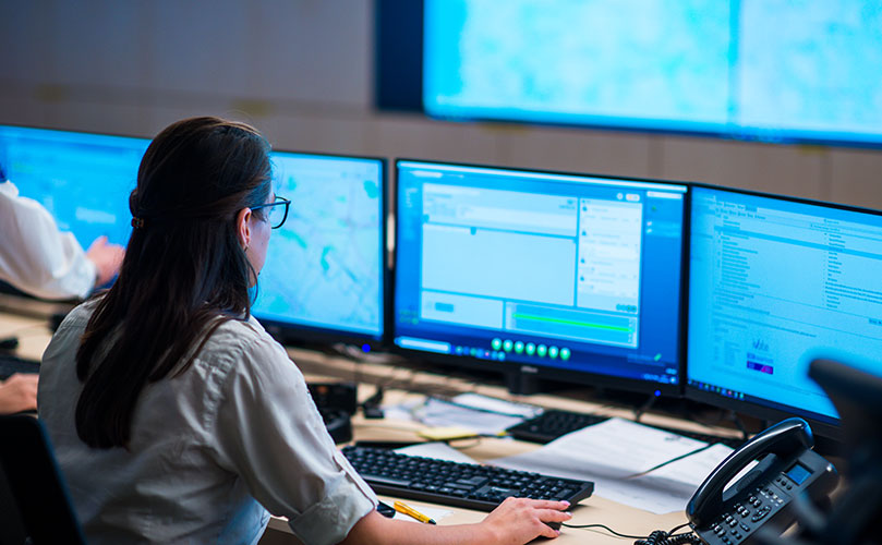 管制室で、複数モニターを使いシステム運用を行う女性