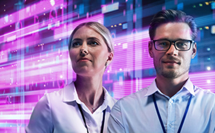 最先端テクノロジーの前に立つ男女。