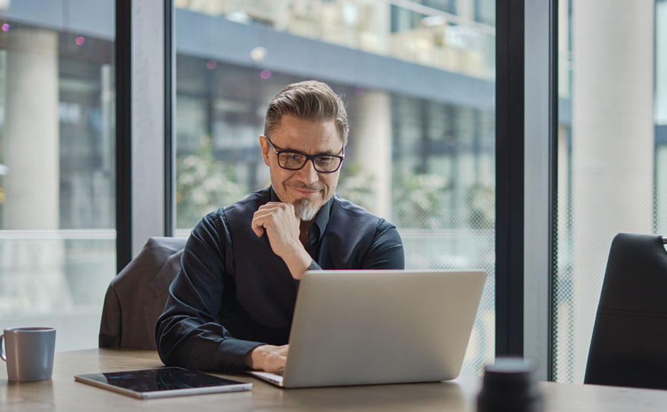A man smiling while running automated tests from his laptop