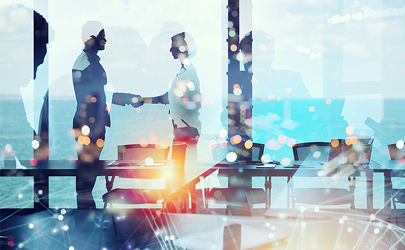 Businessmen shaking hands with an image of light 