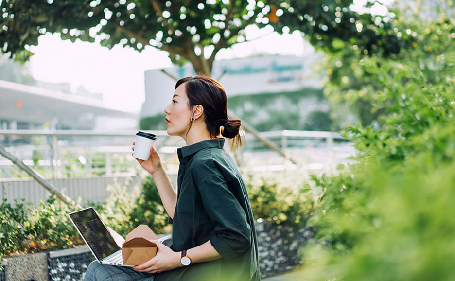 外で飲み物を飲みながら休憩する女性