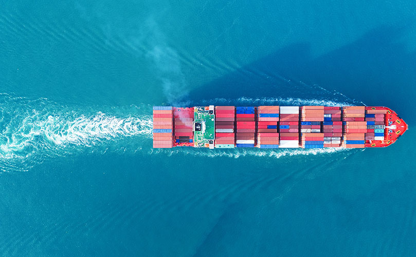 Aerial view of a cargo ship on blue water.