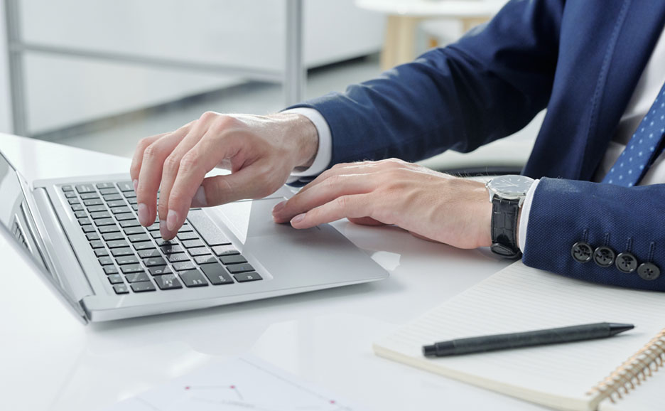 ノートパソコンで作業をする人の手元