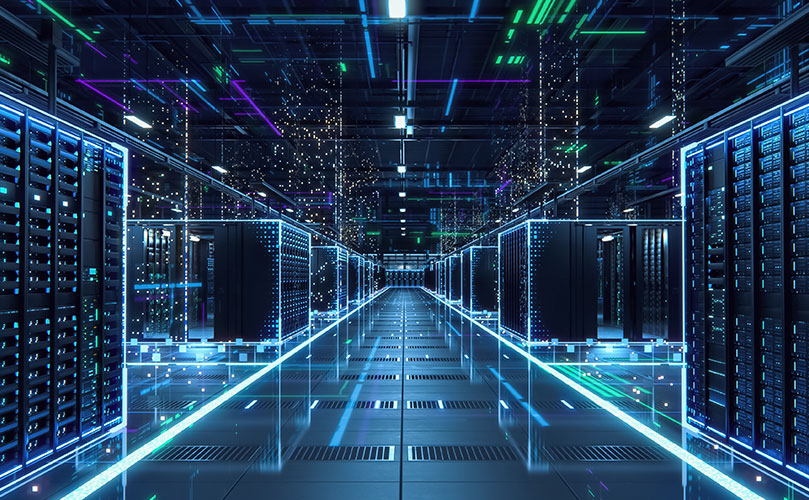 青い照明で照らされた、広大なデータセンターのサーバールーム。