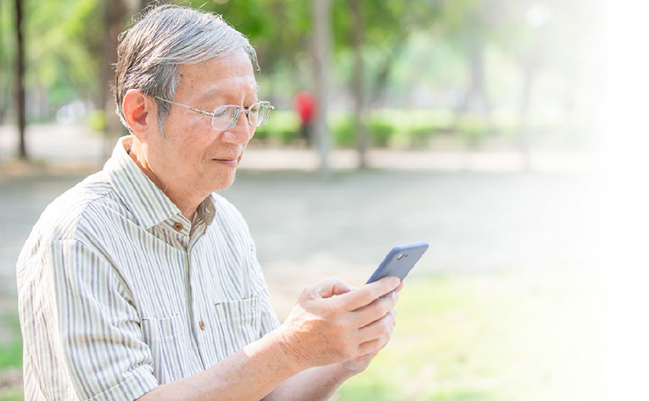 公園でお年寄りがスマートフォンを見てる