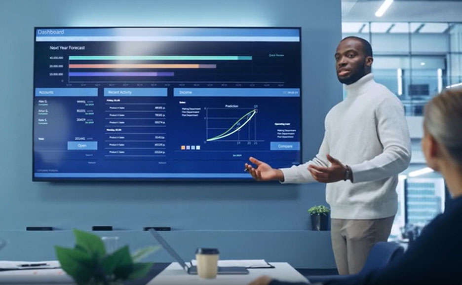 モニタに投影されているデータを説明する男性