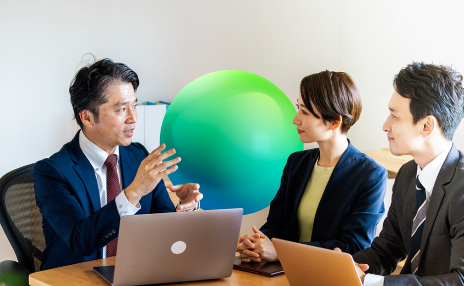 ノートパソコンを広げながら打ち合わせをしている男女3名