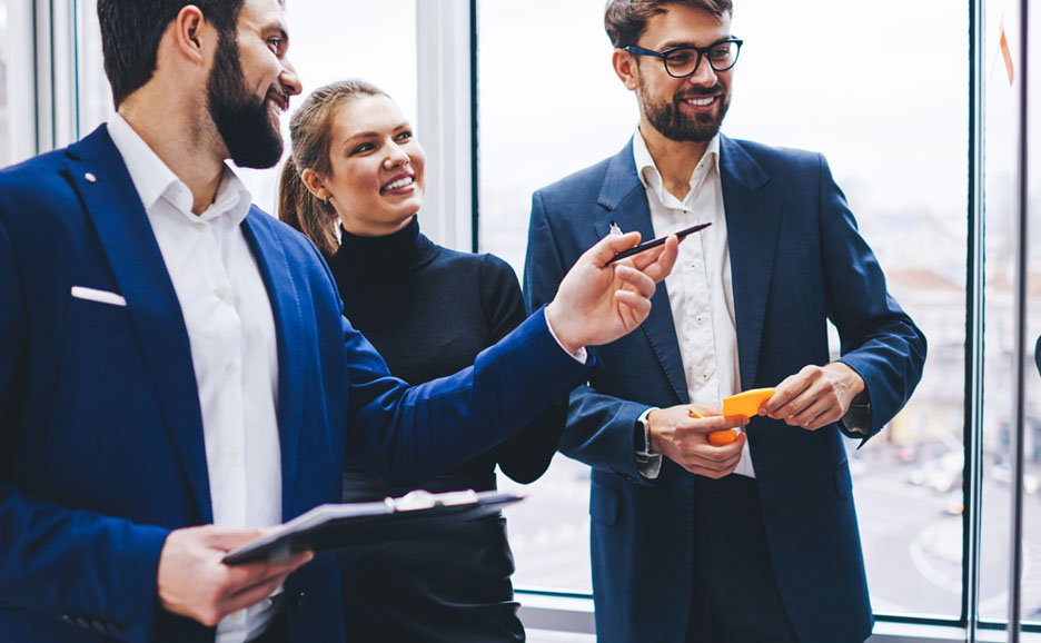 Businessmen pointing at a whiteboard in a meeting