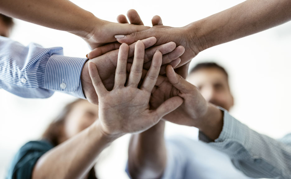 Business team hands stacked together