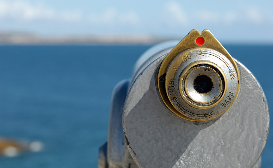Close-up of a telescope set against a sea background