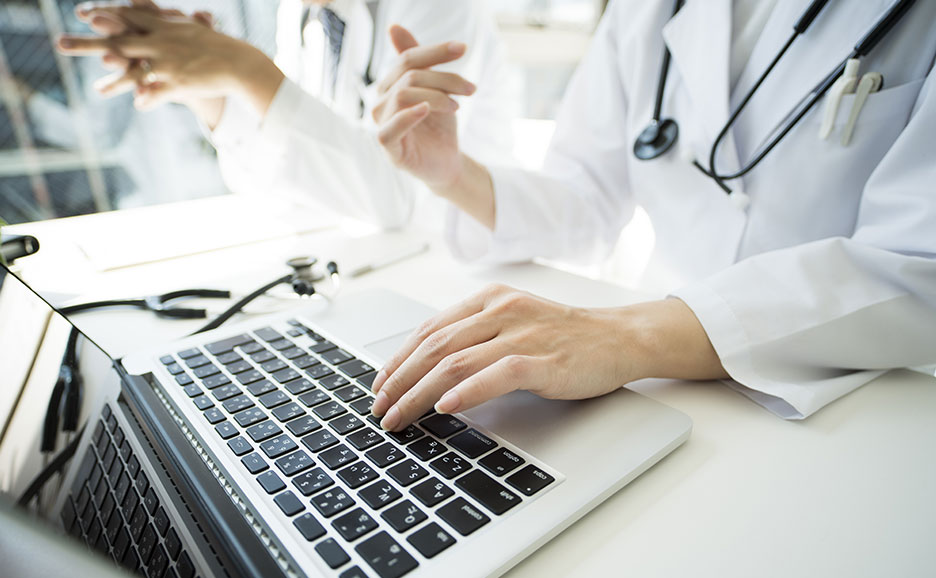 ノートパソコンで作業をする医師