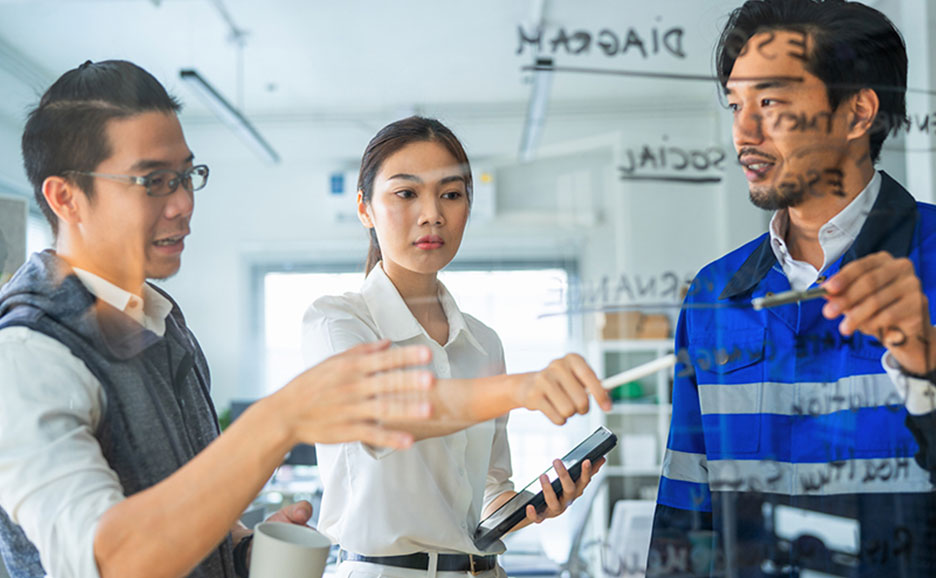 ボード前で議論する3名の男女