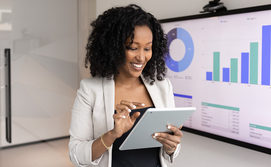 笑顔でタブレットを操作しながらプレゼンテーションを行う女性