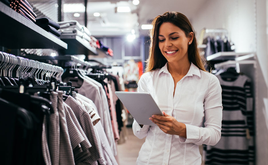 Woman smiling and managing inventory with a tablet in a retail store