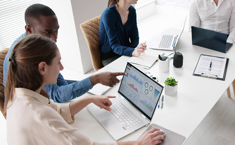 Man and woman in a meeting, reviewing content on a laptop