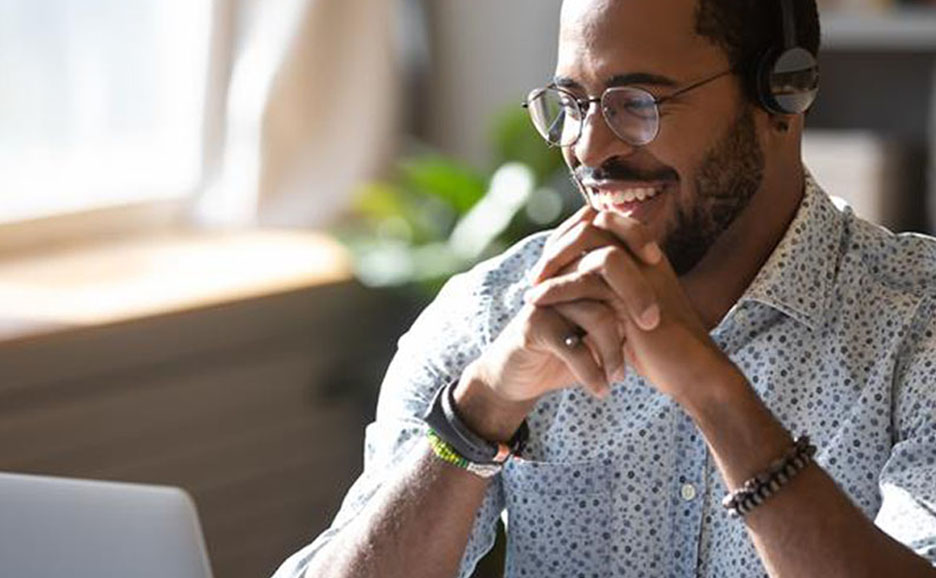 Smiling man looking at a laptop screen
