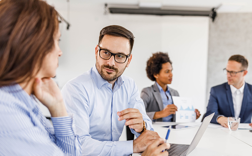 Businesspeople talking in an office meeting.
