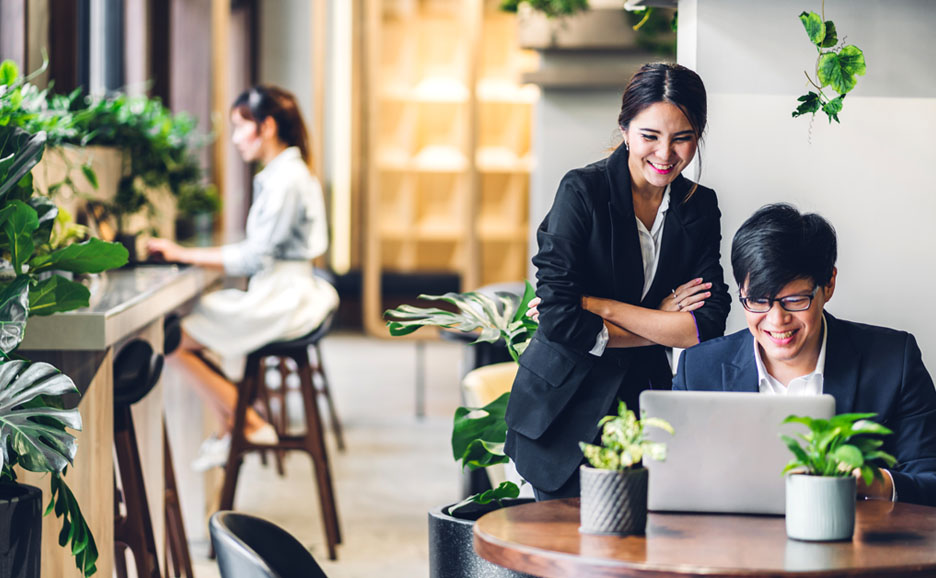 Man operating computer, woman reviewing together