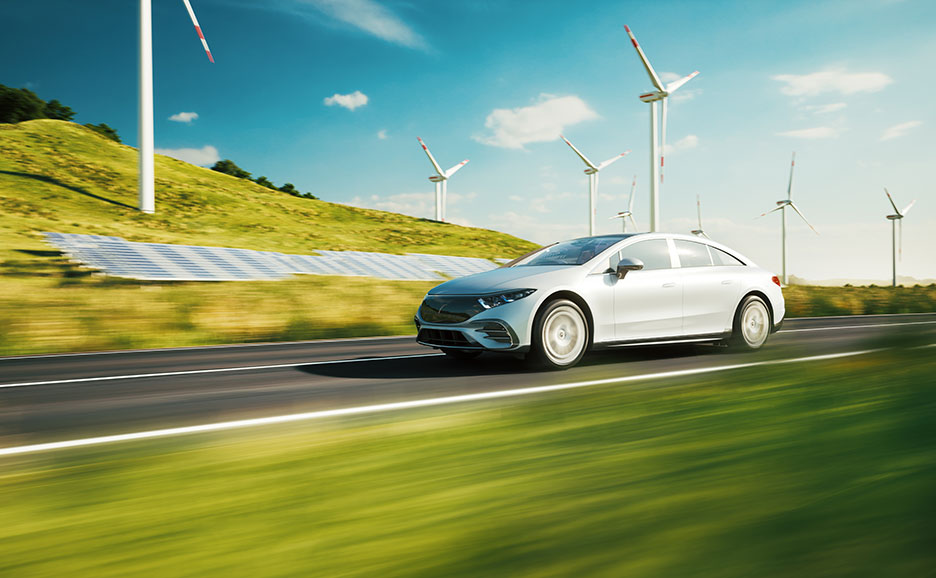 風力発電と太陽光発電の傍らを走る電気自動車