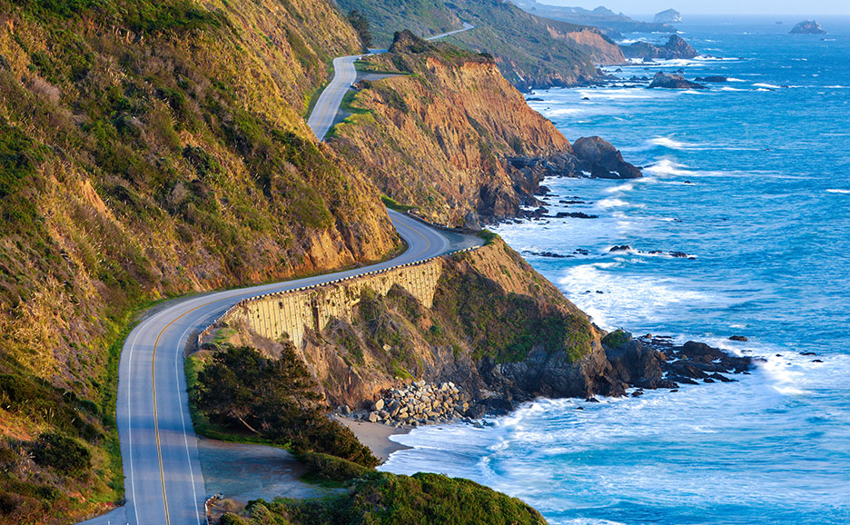 晴れた日に青い海沿いの崖に沿って曲がりくねった道路