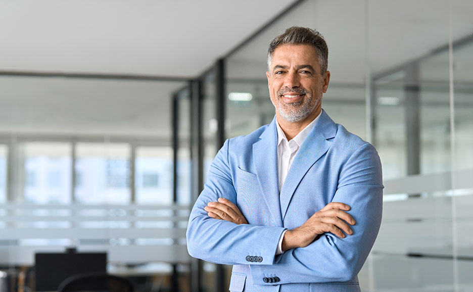 男性が腕組みをして微笑む様子