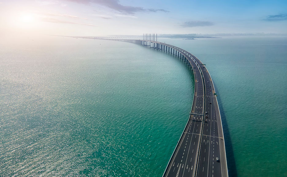 海上を曲線状に延びる長い橋と道路の空撮写真