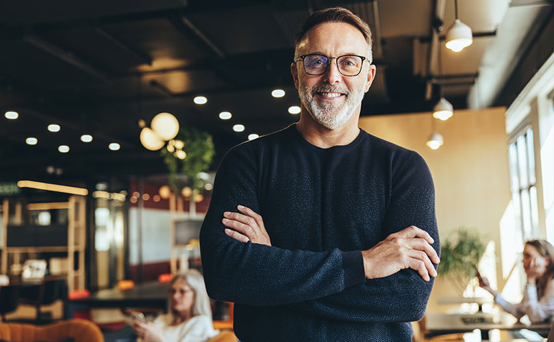 A man with glasses smiling and looking at the camera