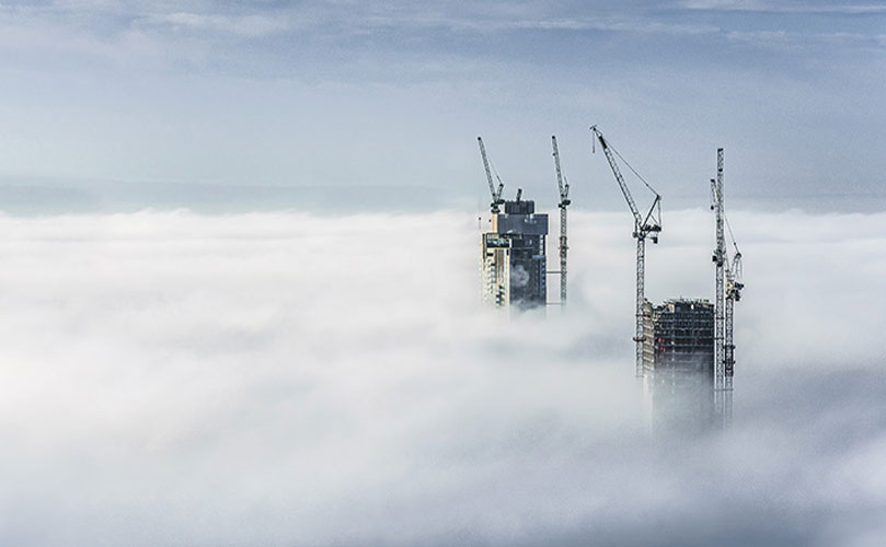 Two tall buildings above the clouds