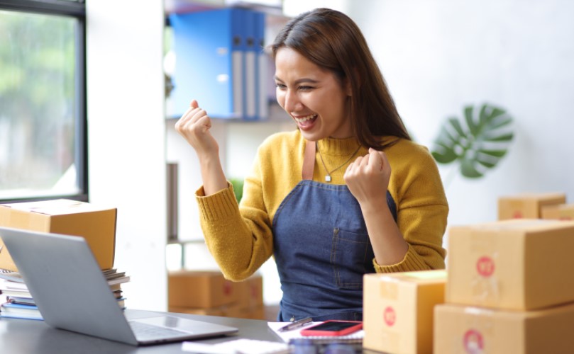 ノートパソコンでネットショッピングをしている若い女性