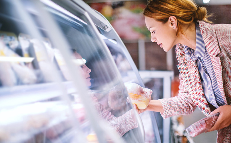 スーパーで食材を選んでいる女性