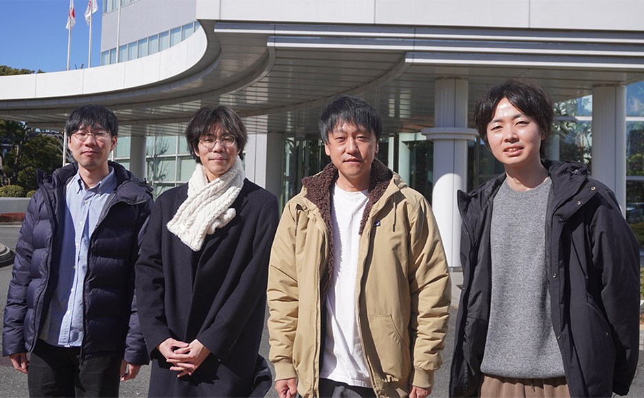 A photo of four researchers standing in line.
