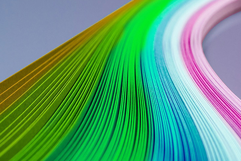 曲線に並べた紙を虹のような色合いで重ね配置した写真