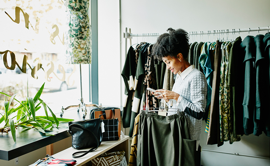 衣料品店でスマートフォンを操作する女性