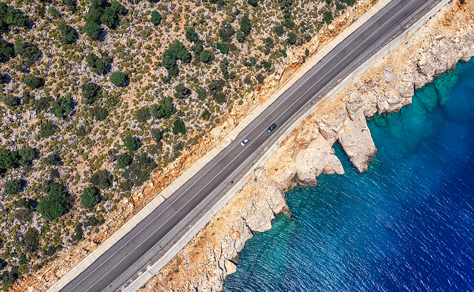 海に近い道路の空撮画像。青い海と緑の景色が広がる美しい風景