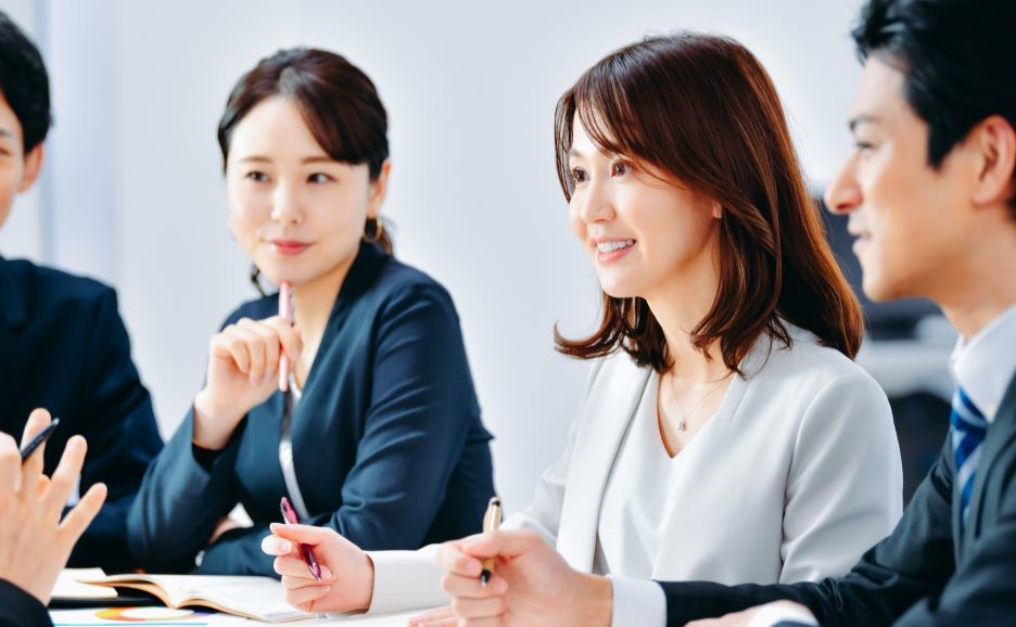 和やかな会議でメモをとる女性