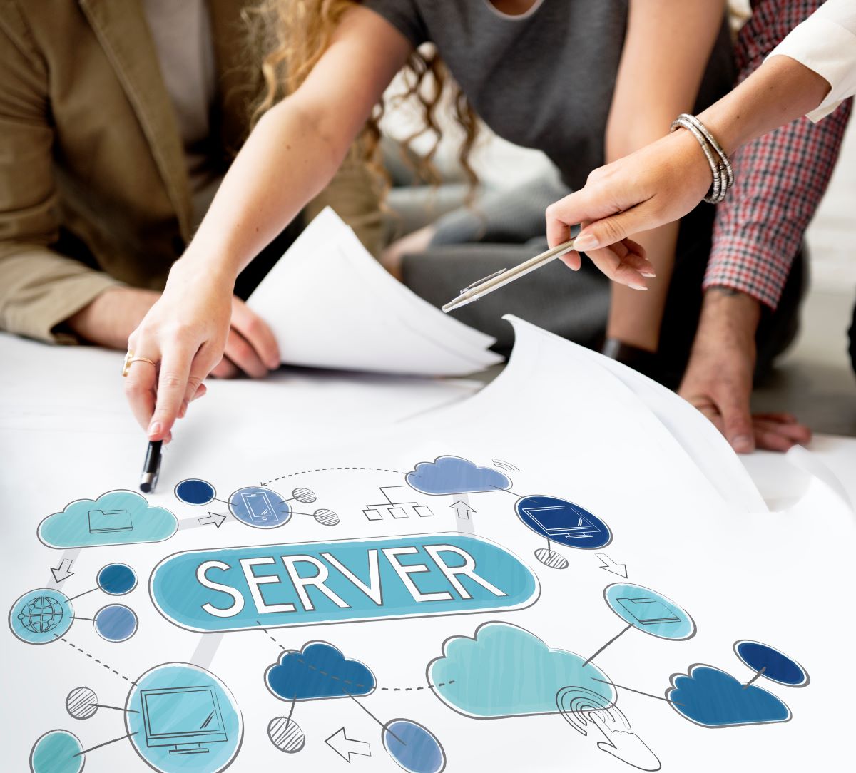 大きな紙に描かれた模式図を中心にして複数人で議論や確認をしている