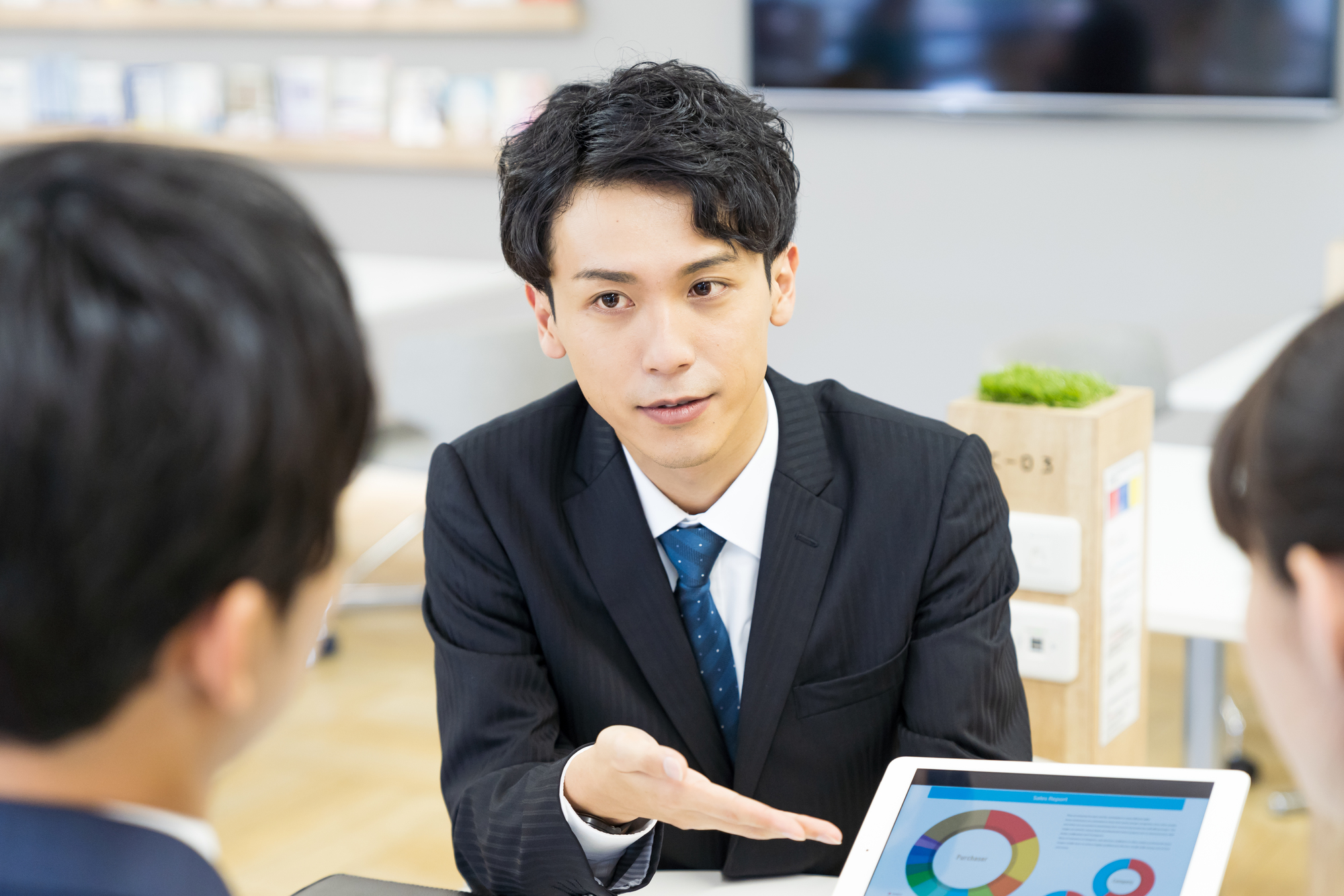 タブレット端末を用いて提案する男性