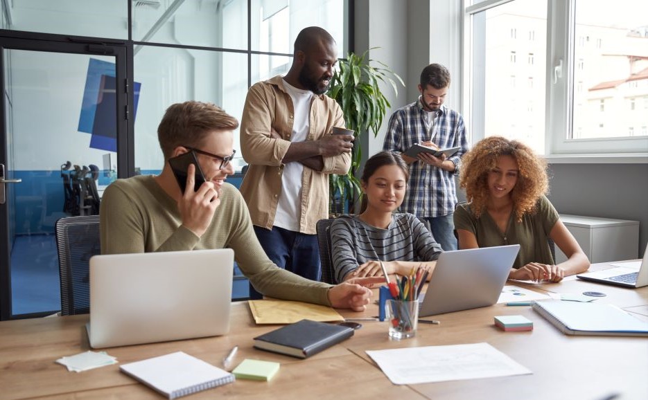 Young people having a friendly meeting around a laptop