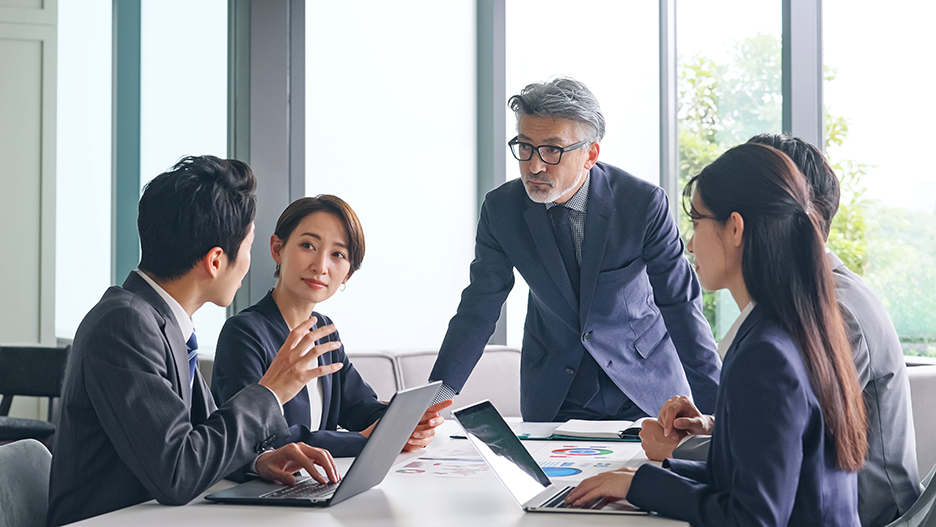 Asian Business Meeting, Grey-haired Man Listens to Young Employee
