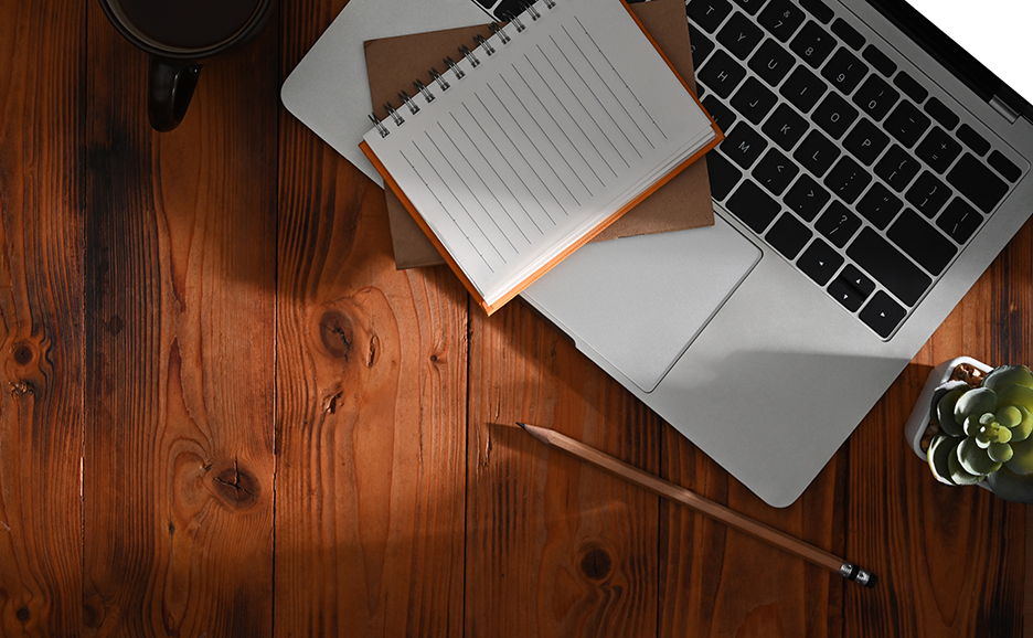 デスクの上にあるノートPCとメモ帳