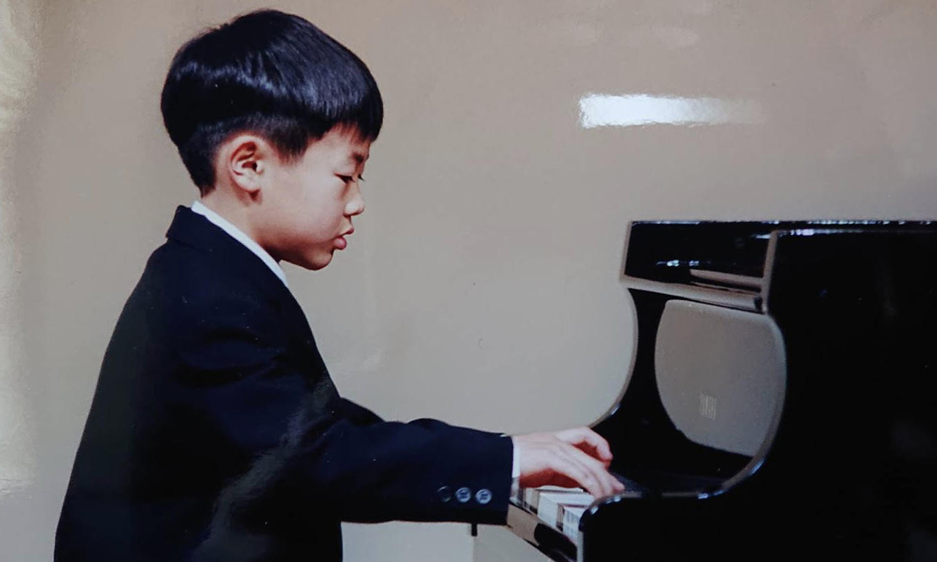 ピアノを弾く幼少期の福岡さん