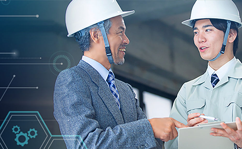 ヘルメットを被った二人の男性が、情報通信技術の背景を前に笑顔で会話している。