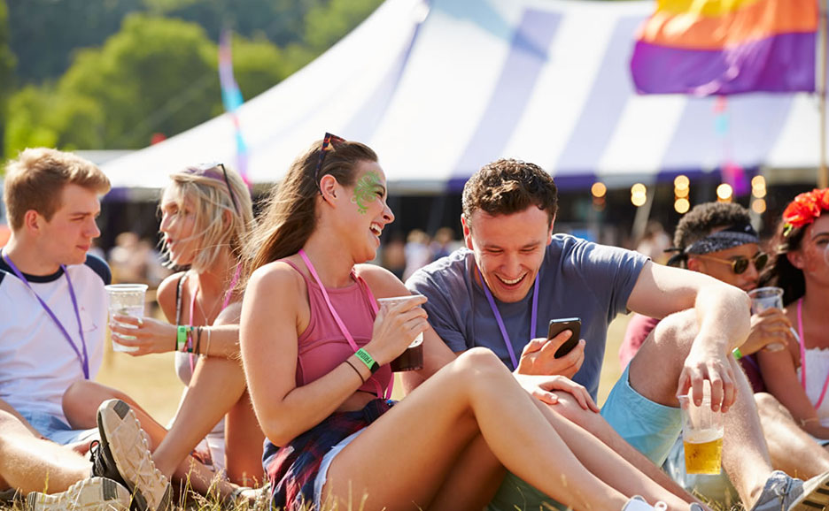 楽しいフェスティバルで、芝生に座って過ごす若者たちのグループ
