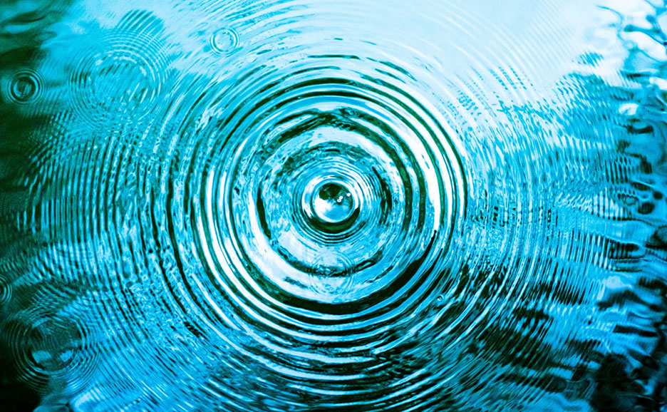 水面に広がる波紋の中心から水滴が落ちる瞬間。