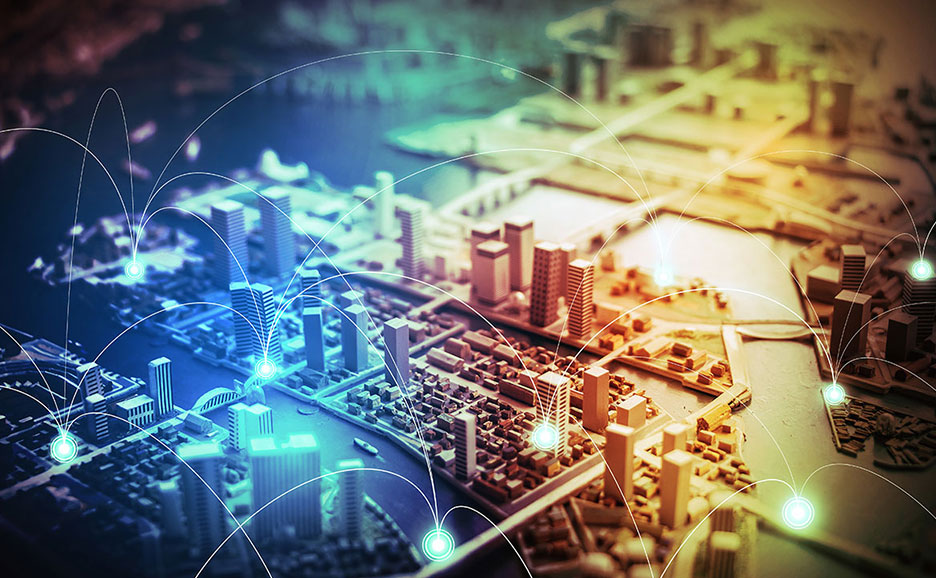IoTスマートシティのような未来都市の模型に、ネットワーク接続を表す線と光が描かれたクローズアップ画像。