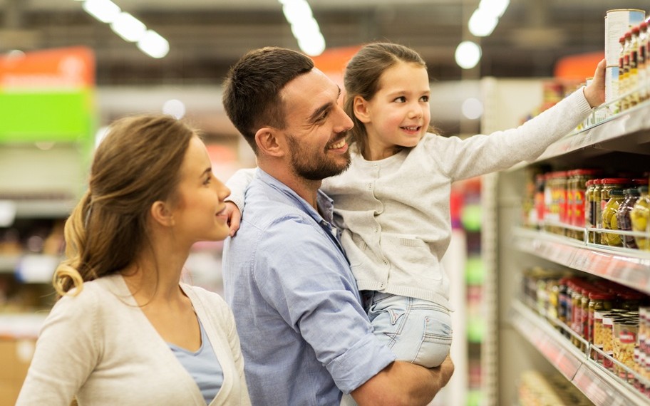 A couple holding their child while selecting items