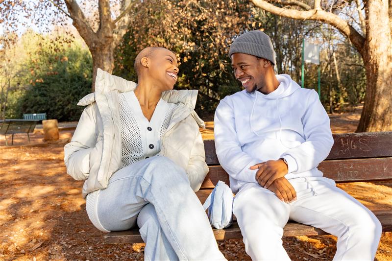 秋の公園,座って談笑する2人の男女