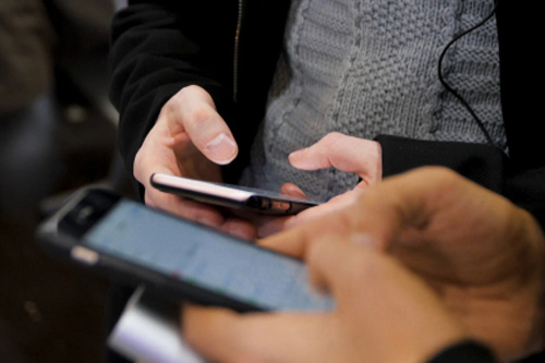 スマートフォンを操作する二人の手元