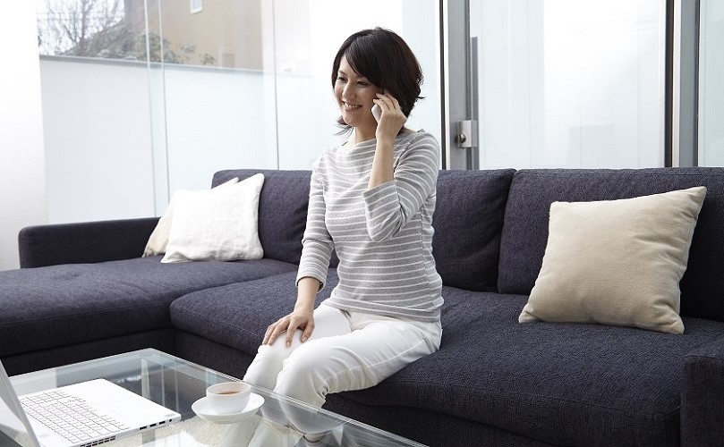 電話をかける笑顔の女性