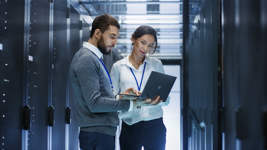 サーバールームでPCを囲んで相談する男女